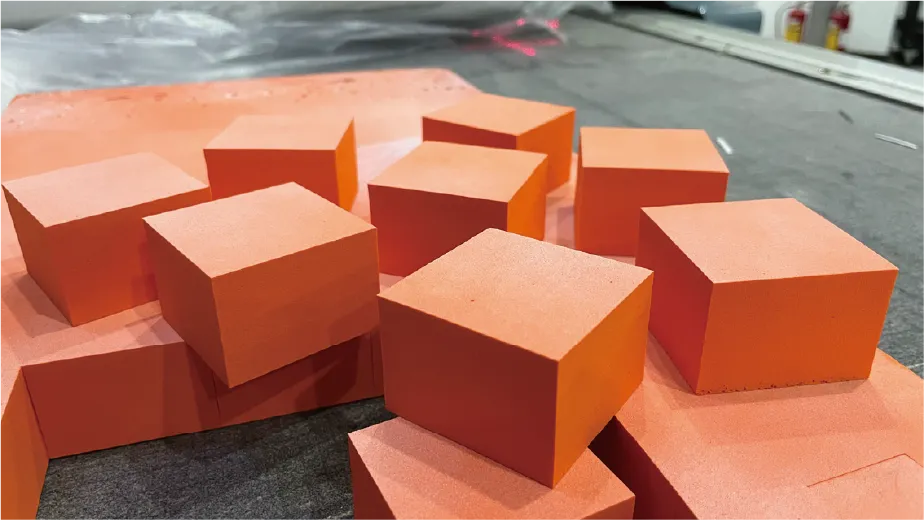 Precision-cut orange EVA foam cubes processed by ZINGCUT CNC cutting machine, showing clean, straight edges