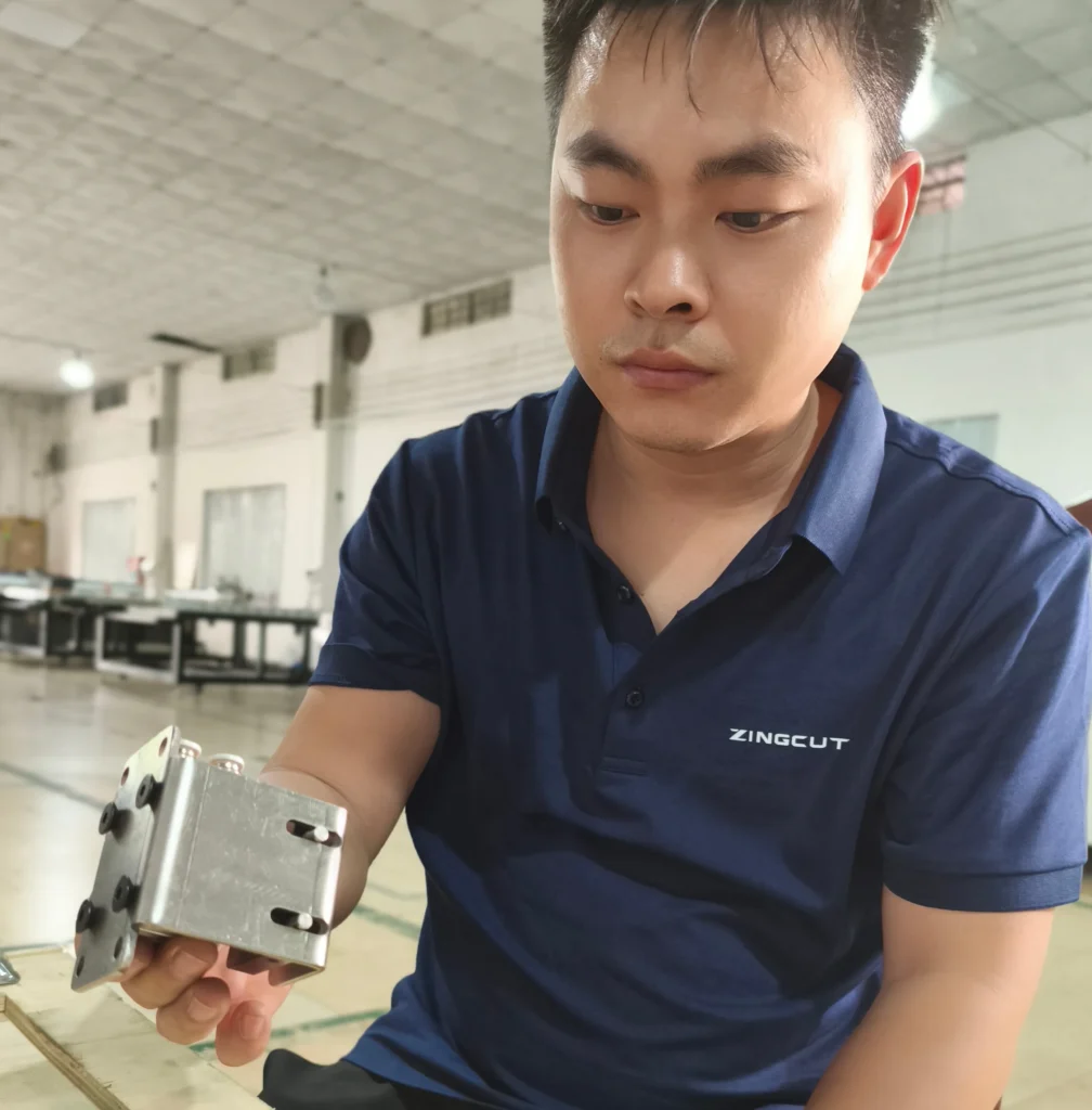 ZINGCUT technical engineer inspecting cutter spare part, FAQ page for oscillating knife digital cutting machine